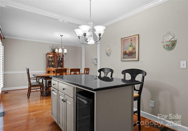 4101 Fairway Downs Ct Unit 9, Charlotte, NC 28277 - kitchen with beverage cooler, a kitchen bar, a chandelier, ornamental molding, and dark countertops