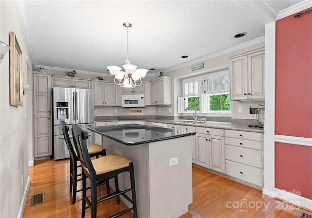 4101 Fairway Downs Ct Unit 9, Charlotte, NC 28277 - kitchen with white microwave, stainless steel refrigerator with ice dispenser, a chandelier, crown molding, and a breakfast bar