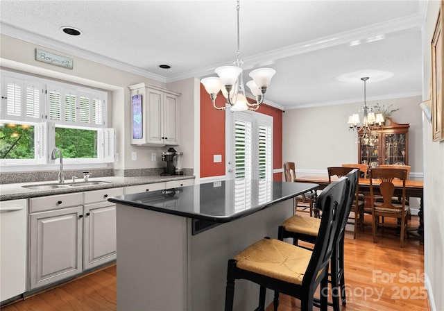 4101 Fairway Downs Ct Unit 9, Charlotte, NC 28277 - kitchen featuring a sink, a chandelier, white dishwasher, light wood-style floors, and ornamental molding