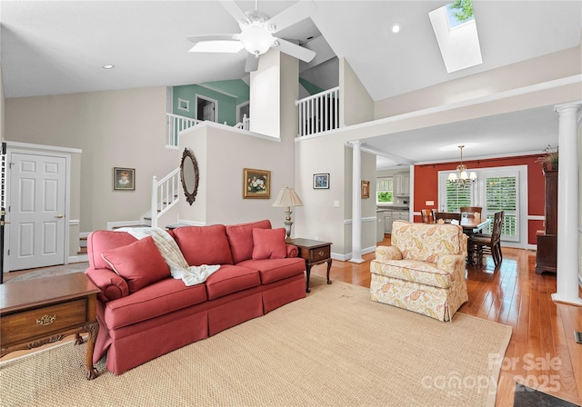 4101 Fairway Downs Ct Unit 9, Charlotte, NC 28277 - living room with ornate columns, a skylight, wood finished floors, a ceiling fan, and a chandelier