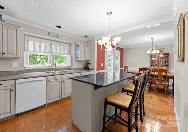 4101 Fairway Downs Ct Unit 9, Charlotte, NC 28277 - kitchen with white dishwasher, a sink, a chandelier, a breakfast bar area, and light wood-style flooring