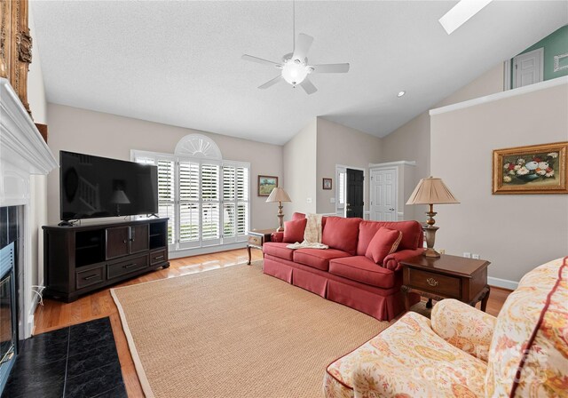 4101 Fairway Downs Ct Unit 9, Charlotte, NC 28277 - living area featuring a ceiling fan, wood finished floors, a fireplace, and high vaulted ceiling