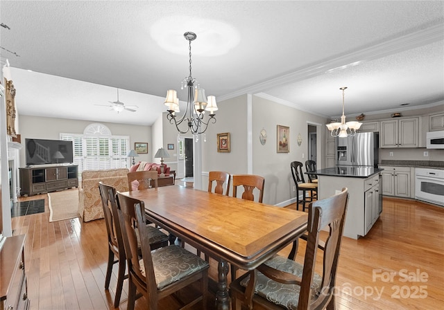 4101 Fairway Downs Ct Unit 9, Charlotte, NC 28277 - dining area with a chandelier, light wood-type flooring, ornamental molding, a ceiling fan, and a textured ceiling