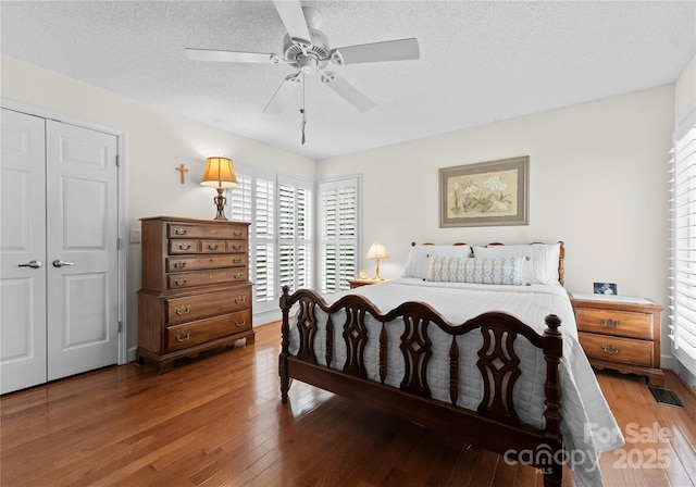 4101 Fairway Downs Ct Unit 9, Charlotte, NC 28277 - bedroom with hardwood / wood-style flooring, a closet, a textured ceiling, and a ceiling fan