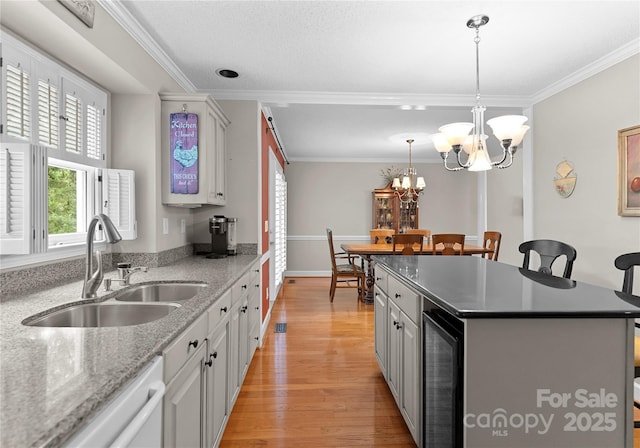 4101 Fairway Downs Ct Unit 9, Charlotte, NC 28277 - kitchen featuring beverage cooler, a sink, a kitchen island, a breakfast bar area, and light wood-type flooring