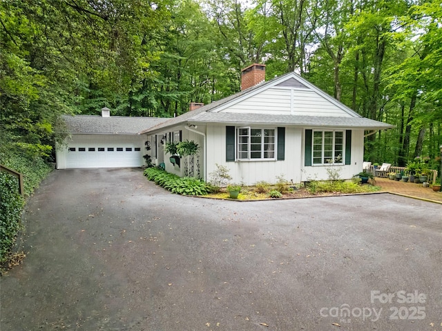 168 River Ridge Rd, Brevard, NC 28712 - single story home with a chimney, driveway, an attached garage, roof with shingles, and board and batten siding