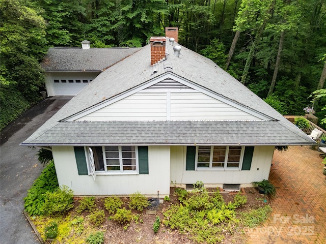 168 River Ridge Rd, Brevard, NC 28712 - view of front of property featuring roof with shingles, driveway, a view of trees, and a chimney