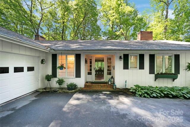 168 River Ridge Rd, Brevard, NC 28712 - entrance to property featuring a chimney, a garage, board and batten siding, and roof with shingles