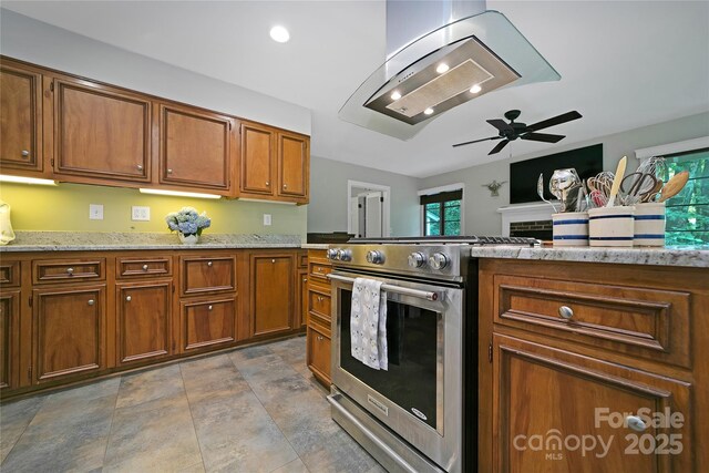 168 River Ridge Rd, Brevard, NC 28712 - kitchen featuring gas range, brown cabinets, a ceiling fan, island exhaust hood, and a fireplace