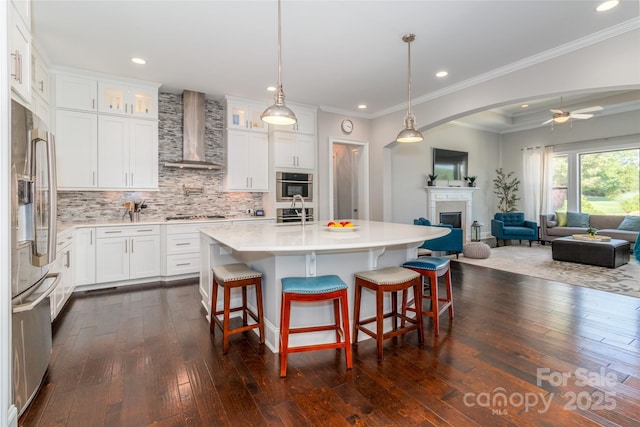 324 Squash Harvest Ct, Matthews, NC 28104 - kitchen with wall chimney exhaust hood, stainless steel refrigerator with ice dispenser, light countertops, a fireplace, and dark wood finished floors