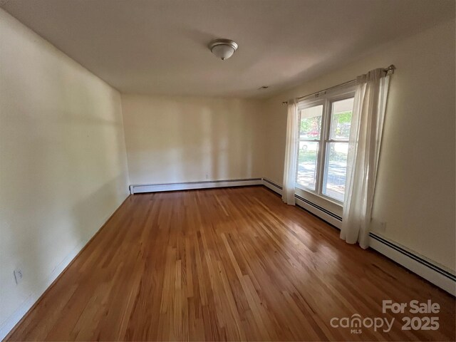 511 Evelyn Ave, Kannapolis, NC 28083 - empty room with wood finished floors, a baseboard heating unit, and baseboards