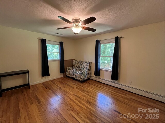 511 Evelyn Ave, Kannapolis, NC 28083 - sitting room with baseboard heating, wood finished floors, ceiling fan, a textured ceiling, and baseboards