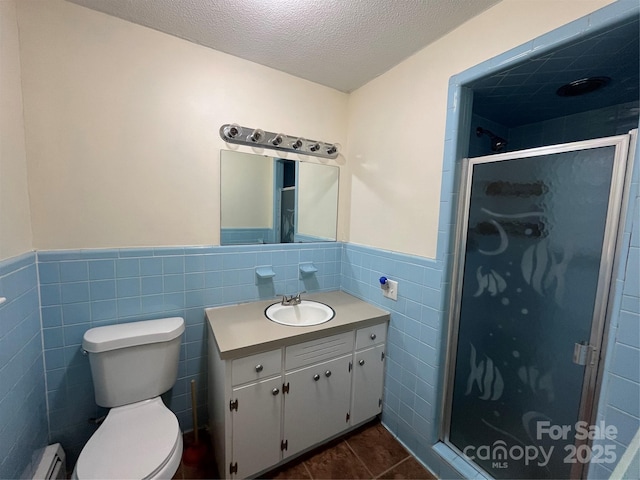511 Evelyn Ave, Kannapolis, NC 28083 - bathroom featuring a baseboard radiator, tile walls, a textured ceiling, vanity, and toilet
