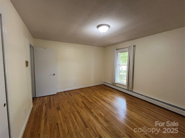 511 Evelyn Ave, Kannapolis, NC 28083 - empty room with hardwood / wood-style floors, baseboard heating, a textured ceiling, and baseboards