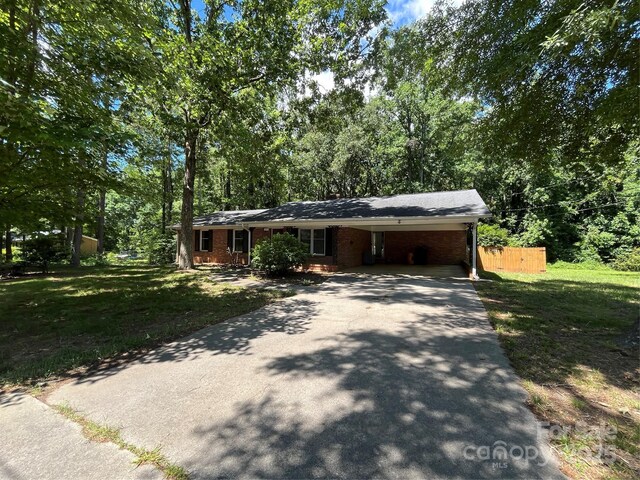 511 Evelyn Ave, Kannapolis, NC 28083 - ranch-style home with driveway, brick siding, a front lawn, and an attached carport