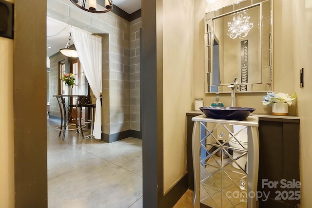 14701 Cabarrus Rd, Mint Hill, NC 28227 - hallway with a chandelier, a sink, concrete flooring, and baseboards
