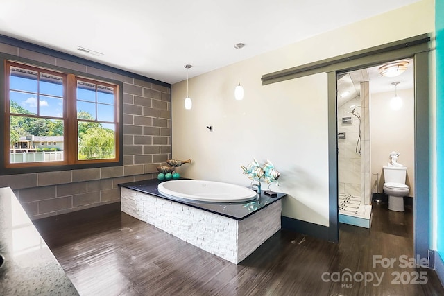 14701 Cabarrus Rd, Mint Hill, NC 28227 - full bathroom with wood finished floors, a garden tub, tiled shower, toilet, and baseboards