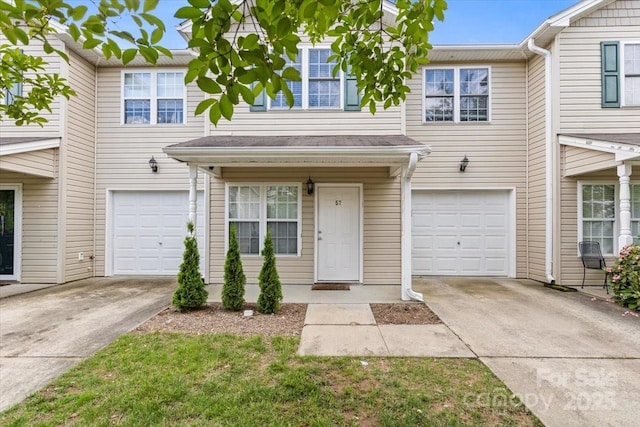 multi unit property featuring an attached garage and concrete driveway