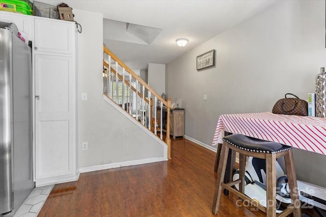 dining space featuring stairway, wood finished floors, and baseboards