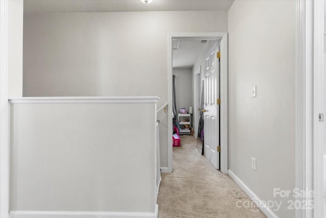 corridor featuring carpet floors, an upstairs landing, and baseboards