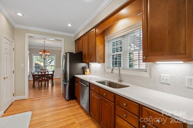 3124 17th Street Ln NE, Hickory, NC 28601 - kitchen with stainless steel appliances, a sink, a chandelier, light wood-type flooring, and ornamental molding
