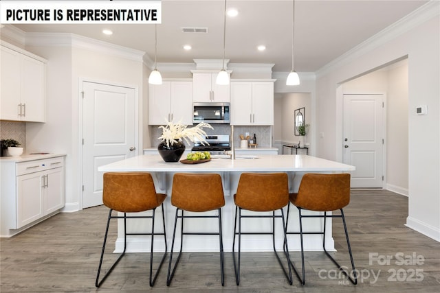 121 S Shayna Rd, Troutman, NC 28166 - kitchen with stainless steel appliances, a kitchen bar, crown molding, light countertops, and decorative backsplash