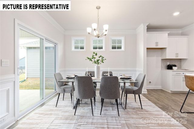 121 S Shayna Rd, Troutman, NC 28166 - dining room with a chandelier, crown molding, light wood-style floors, and a wainscoted wall