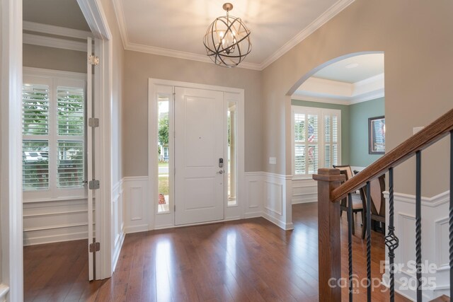 3666 Jacinta Ct, Tega Cay, SC 29708 - entryway with arched walkways, dark wood-style flooring, ornamental molding, a wainscoted wall, and a chandelier
