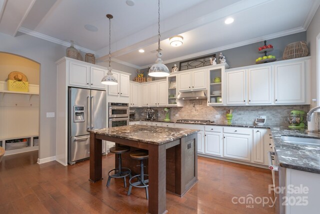 3666 Jacinta Ct, Tega Cay, SC 29708 - kitchen with appliances with stainless steel finishes, a sink, under cabinet range hood, decorative backsplash, and dark stone countertops