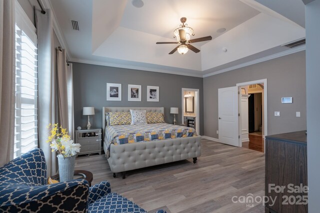 3666 Jacinta Ct, Tega Cay, SC 29708 - bedroom featuring a tray ceiling, multiple windows, wood finished floors, and ornamental molding