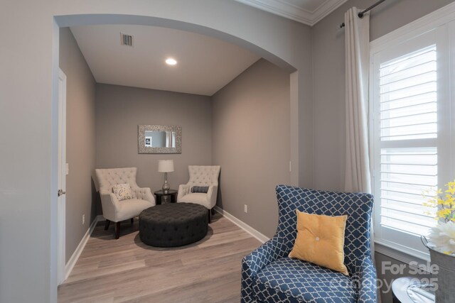 3666 Jacinta Ct, Tega Cay, SC 29708 - sitting room featuring arched walkways, light wood-style floors, plenty of natural light, baseboards, and crown molding