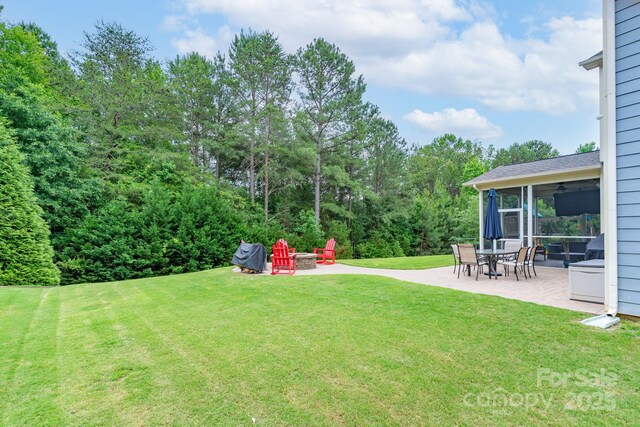 3666 Jacinta Ct, Tega Cay, SC 29708 - view of grassy yard with a patio area, a fire pit, and a sunroom