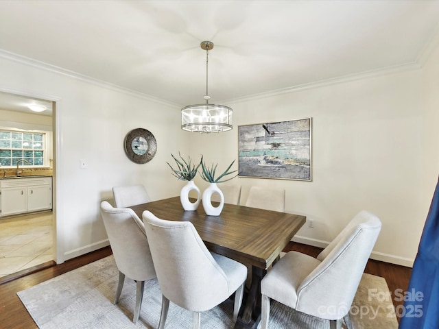 1049 Regency Dr, Charlotte, NC 28211 - dining room featuring a chandelier, crown molding, wood finished floors, and baseboards