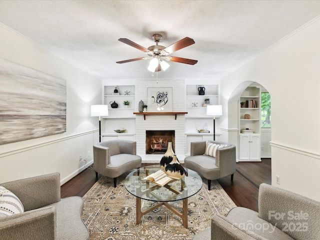 1049 Regency Dr, Charlotte, NC 28211 - living room featuring wood finished floors, ceiling fan, built in shelves, and a fireplace
