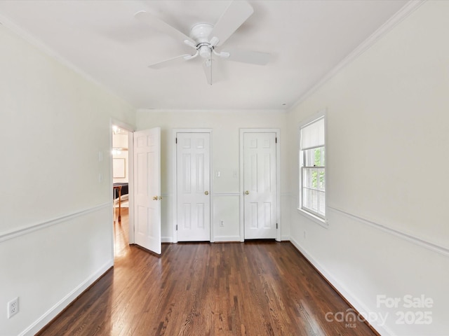1049 Regency Dr, Charlotte, NC 28211 - unfurnished bedroom featuring dark wood-type flooring, baseboards, ornamental molding, multiple closets, and ceiling fan