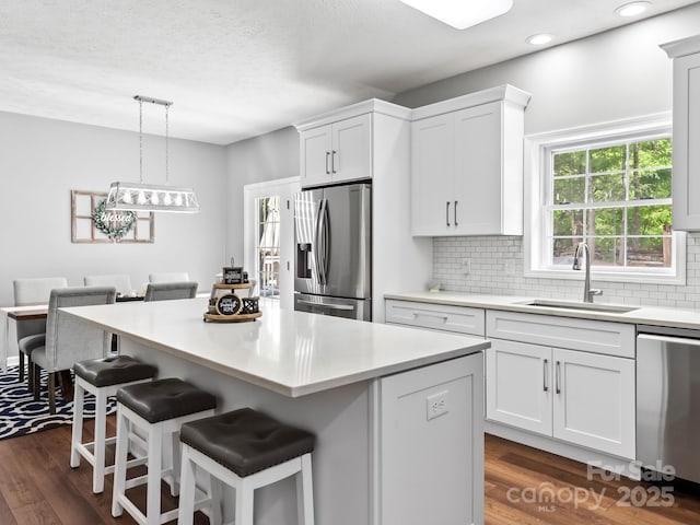 642 Bull Creek Rd, Mars Hill, NC 28754 - kitchen featuring stainless steel appliances, a sink, white cabinets, a breakfast bar, and decorative backsplash