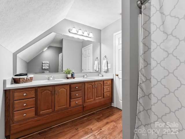 642 Bull Creek Rd, Mars Hill, NC 28754 - bathroom featuring vaulted ceiling, wood finished floors, a textured ceiling, and double vanity