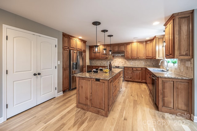 206 Ridge Top Dr, Connelly Springs, NC 28612 - kitchen featuring stainless steel appliances, a sink, brown cabinetry, under cabinet range hood, and light wood-style floors