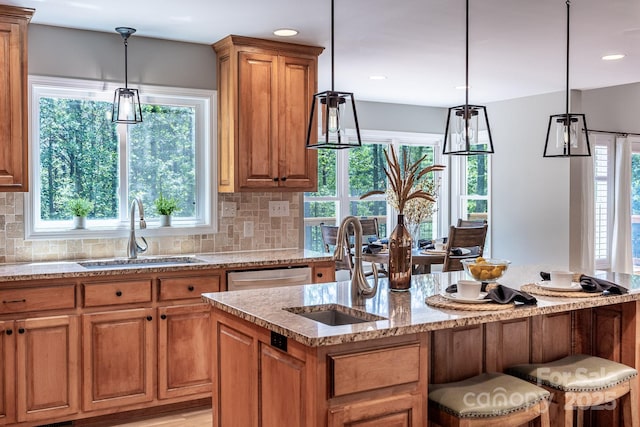 206 Ridge Top Dr, Connelly Springs, NC 28612 - kitchen featuring a sink, light stone counters, brown cabinets, decorative backsplash, and healthy amount of natural light