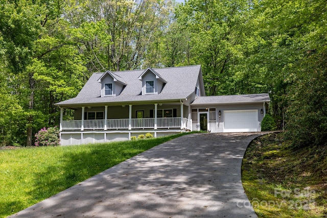 view of front facade with covered porch, an attached garage, concrete driveway, and roof with shingles