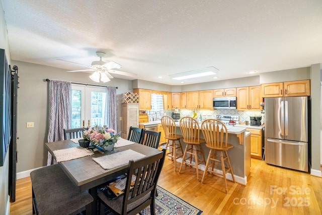 dining area featuring light wood-style flooring, a ceiling fan, baseboards, and recessed lighting