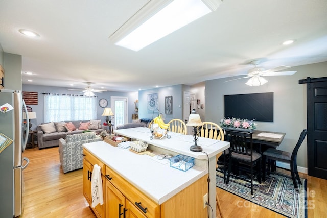kitchen featuring a ceiling fan, freestanding refrigerator, open floor plan, light wood-style floors, and recessed lighting