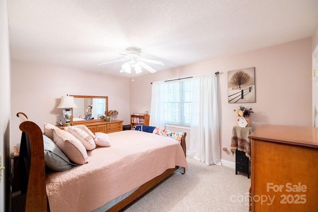 bedroom featuring light colored carpet, a ceiling fan, and baseboards