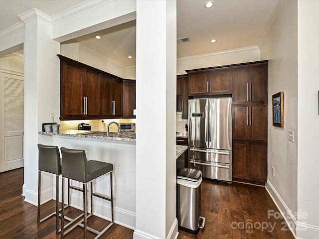 5425 Closeburn Rd, Charlotte, NC 28210 - kitchen featuring freestanding refrigerator, light stone countertops, dark wood-type flooring, ornamental molding, and dark brown cabinetry