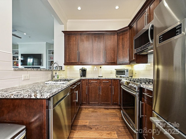 5425 Closeburn Rd, Charlotte, NC 28210 - kitchen with appliances with stainless steel finishes, light stone counters, a sink, crown molding, and dark wood finished floors