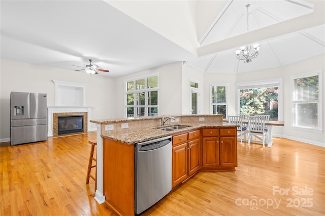 10024 Hazelview Dr, Charlotte, NC 28277 - kitchen featuring stainless steel appliances, a sink, brown cabinetry, and light wood-style flooring