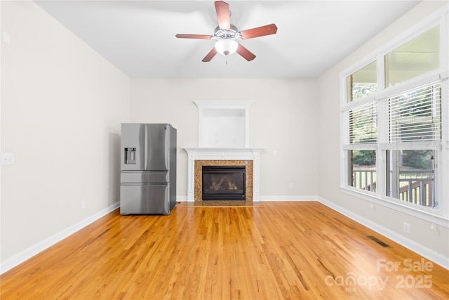 10024 Hazelview Dr, Charlotte, NC 28277 - unfurnished living room with light wood finished floors, ceiling fan, a high end fireplace, and baseboards