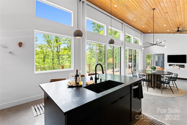 7 Big Rocky Top Dr, Weaverville, NC 28787 - kitchen featuring wooden ceiling, concrete floors, dark cabinetry, a high ceiling, and a kitchen island with sink
