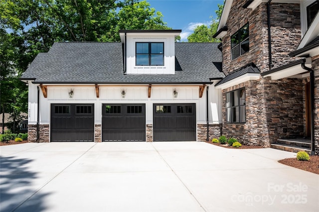 7703 Juniper Ln, Denver, NC 28037 - view of front facade with board and batten siding, stone siding, and a garage