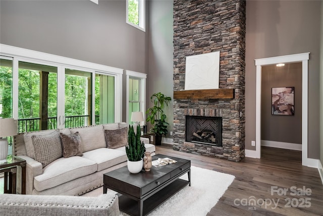 7703 Juniper Ln, Denver, NC 28037 - living room with a towering ceiling, baseboards, a stone fireplace, and wood finished floors